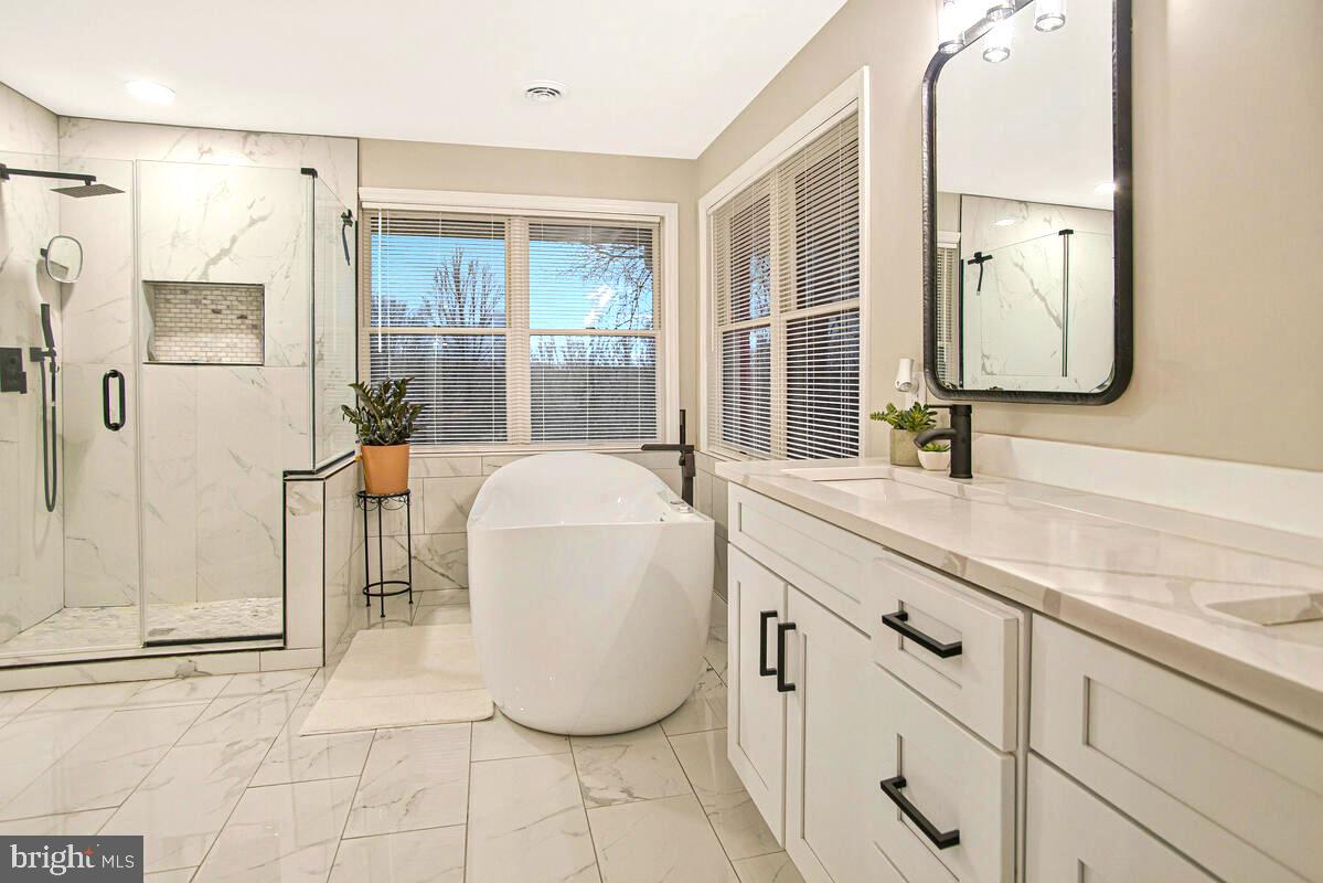 8241 Surratts Road Clinton, MD 20735 - Photo 36 of 55 a bathroom with a tub sink and mirror