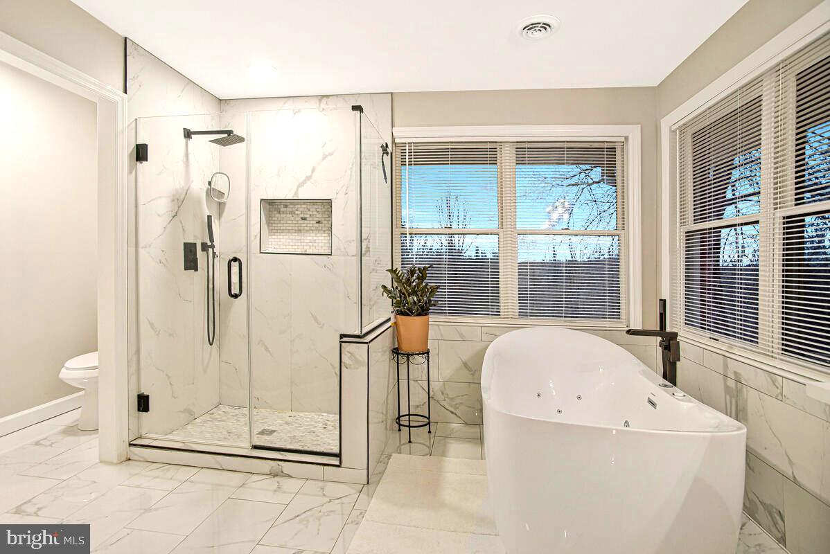 8241 Surratts Road Clinton, MD 20735 - Photo 39 of 55 a bathroom with a tub shower and mirror