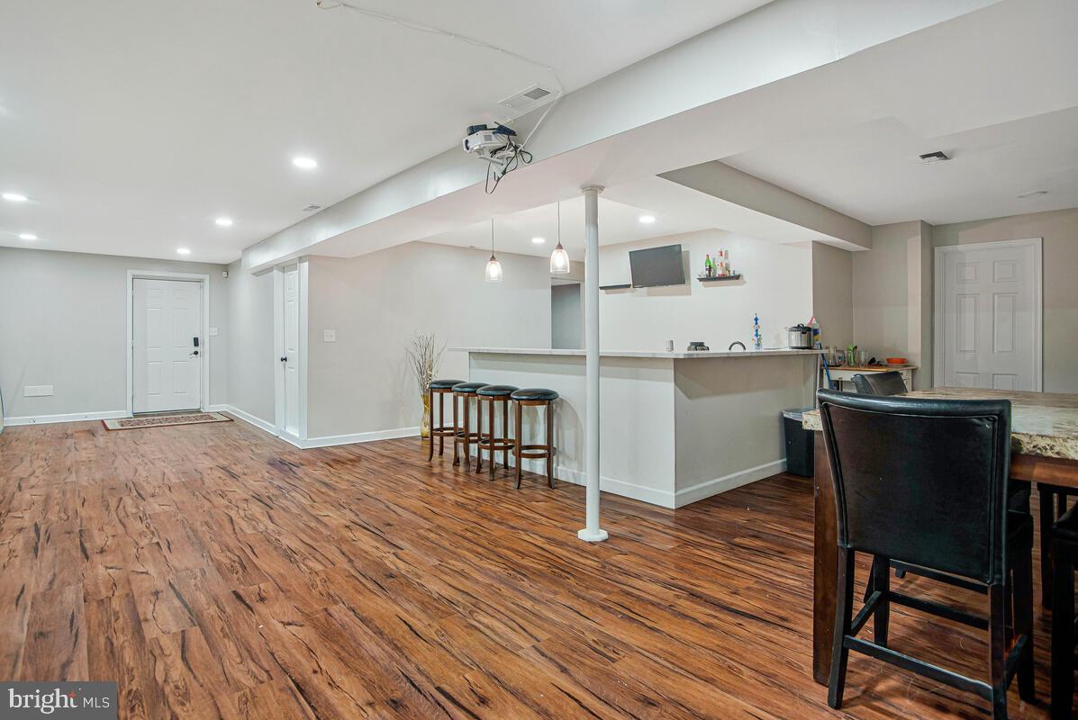 8241 Surratts Road Clinton, MD 20735 - Photo 43 of 55 a kitchen with stainless steel appliances granite countertop a refrigerator a stove a sink dishwasher and a dining table with wooden floor
