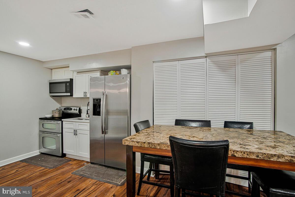 8241 Surratts Road Clinton, MD 20735 - Photo 44 of 55 a kitchen with granite countertop a sink appliances cabinets and wooden floor