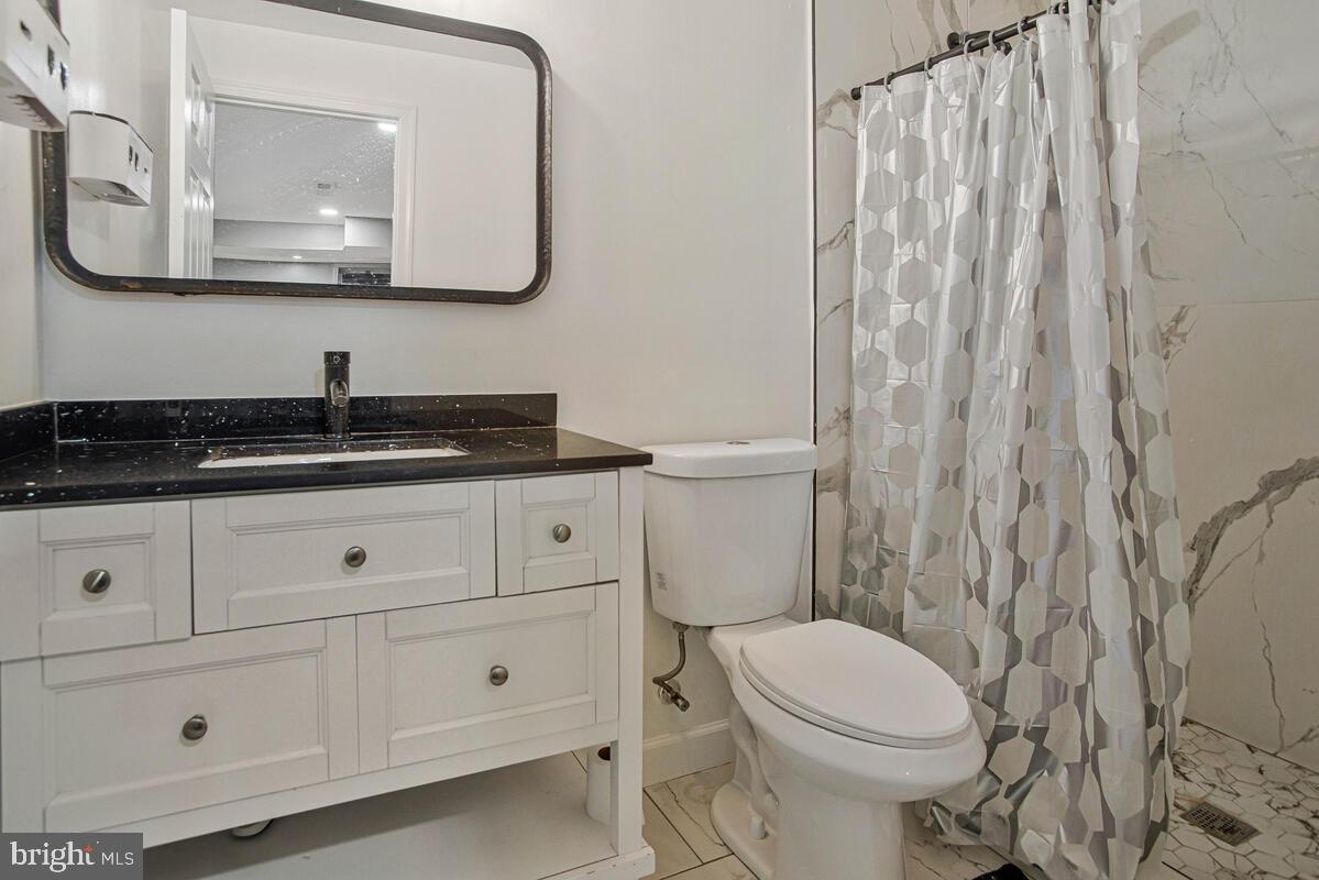 8241 Surratts Road Clinton, MD 20735 - Photo 49 of 55 a bathroom with a granite countertop toilet sink and mirror