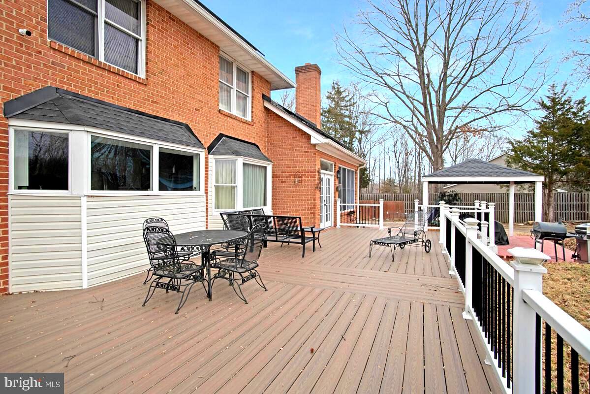 8241 Surratts Road Clinton, MD 20735 - Photo 51 of 55 a view of a patio with table and chairs and wooden floor