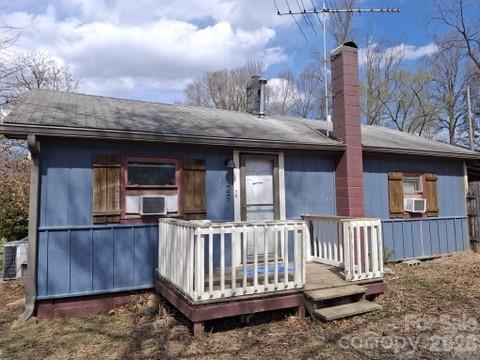 a view of a house with wooden deck and furniture