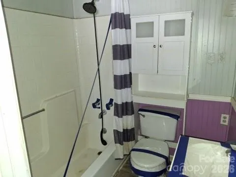 a bathroom with a toilet and a shower