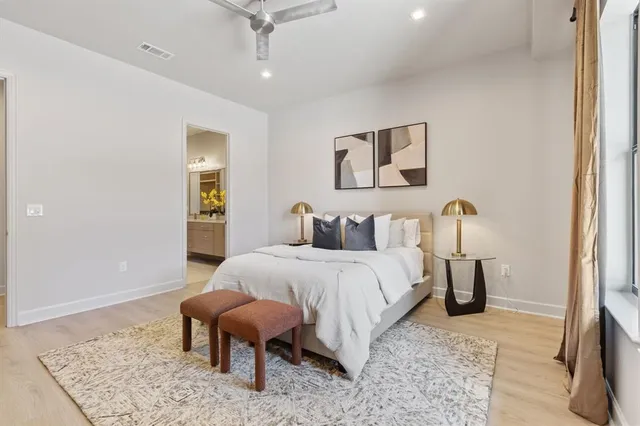 a spacious bedroom with a bed and wooden floor