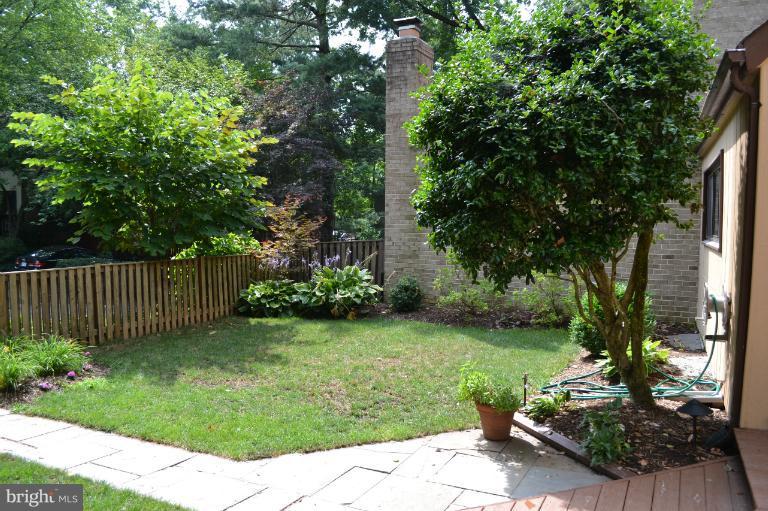10911 Knights Bridge Court Reston, VA 20190 - Photo 20 of 30 a view of a backyard with potted plants and large trees
