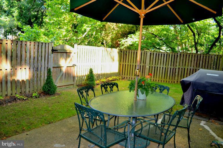 10911 Knights Bridge Court Reston, VA 20190 - Photo 25 of 30 a table and chairs in patio with wooden fence