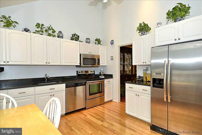10911 Knights Bridge Court Reston, VA 20190 - Photo 26 of 30 a kitchen with granite countertop a refrigerator and a stove top oven