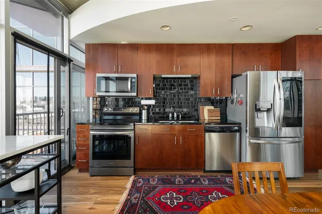 a kitchen with stainless steel appliances granite countertop a refrigerator stove microwave and sink