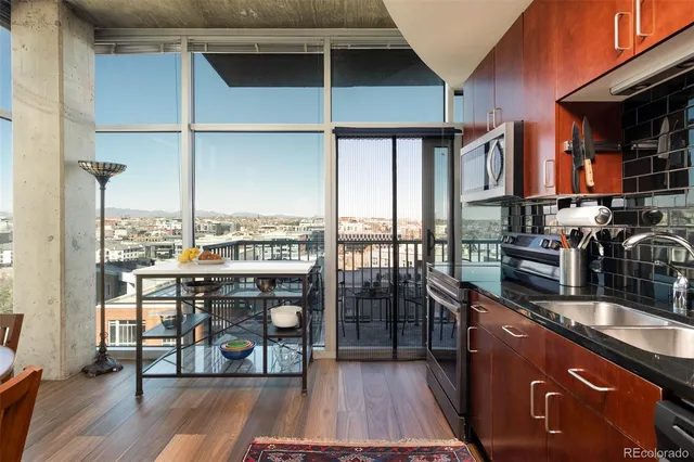 a kitchen with stainless steel appliances granite countertop a stove top oven a sink and a wooden floors