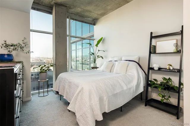 a bed sitting in a bedroom next to a window