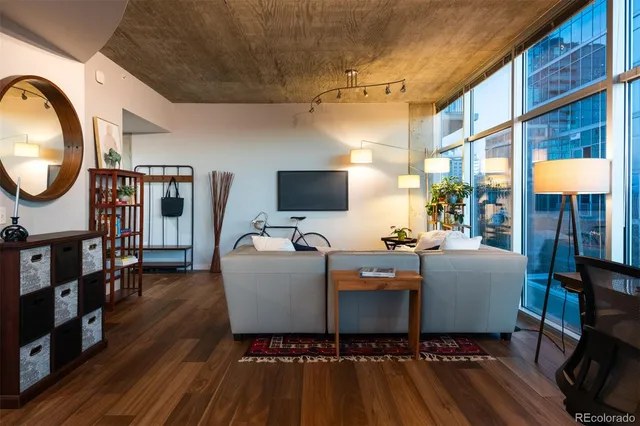 a living room with furniture a flat screen tv and a floor to ceiling window