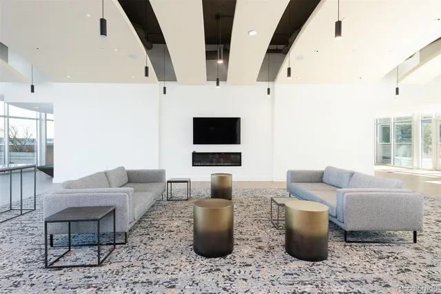 a living room with furniture a large window and wooden floor