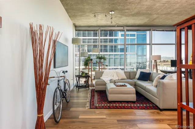 a living room with furniture fireplace and a large window