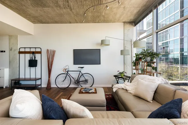 a living room with furniture a flat screen tv and a large window