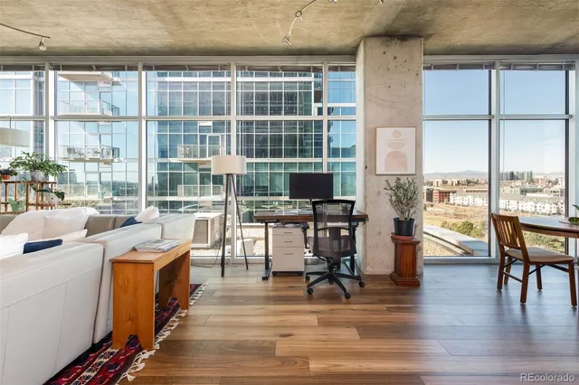 a view of a living room with furniture and floor to ceiling windows