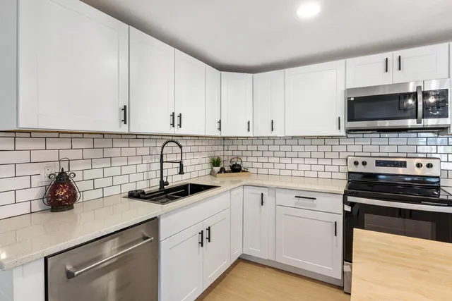 a kitchen with cabinets stainless steel appliances and a sink
