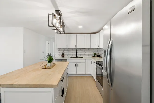 a kitchen with kitchen island granite countertop a sink stainless steel appliances and cabinets