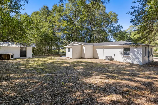 a view of a house with backyard and a tree