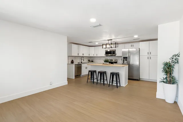 a kitchen with kitchen island a counter top space a sink appliances and cabinets