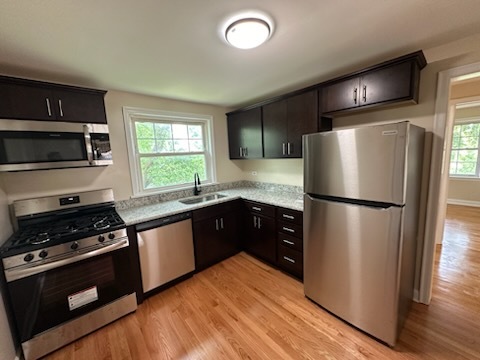 4246 West Nelson Street, Unit 2 Chicago, IL 60641 - Photo 2 of 12 a kitchen with granite countertop a refrigerator stove and microwave