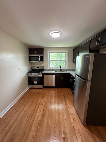 4246 West Nelson Street, Unit 2 Chicago, IL 60641 - Photo 3 of 12 a kitchen with granite countertop a refrigerator and a sink