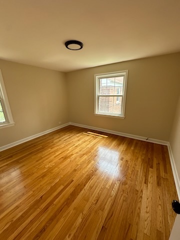 4246 West Nelson Street, Unit 2 Chicago, IL 60641 - Photo 10 of 12 a view of empty room with wooden floor and fan