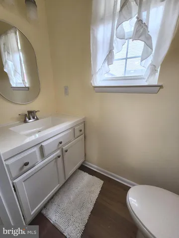 a bathroom with a toilet a sink and mirror