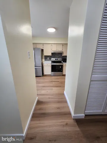 a view of a kitchen with wooden floor and electronic appliances