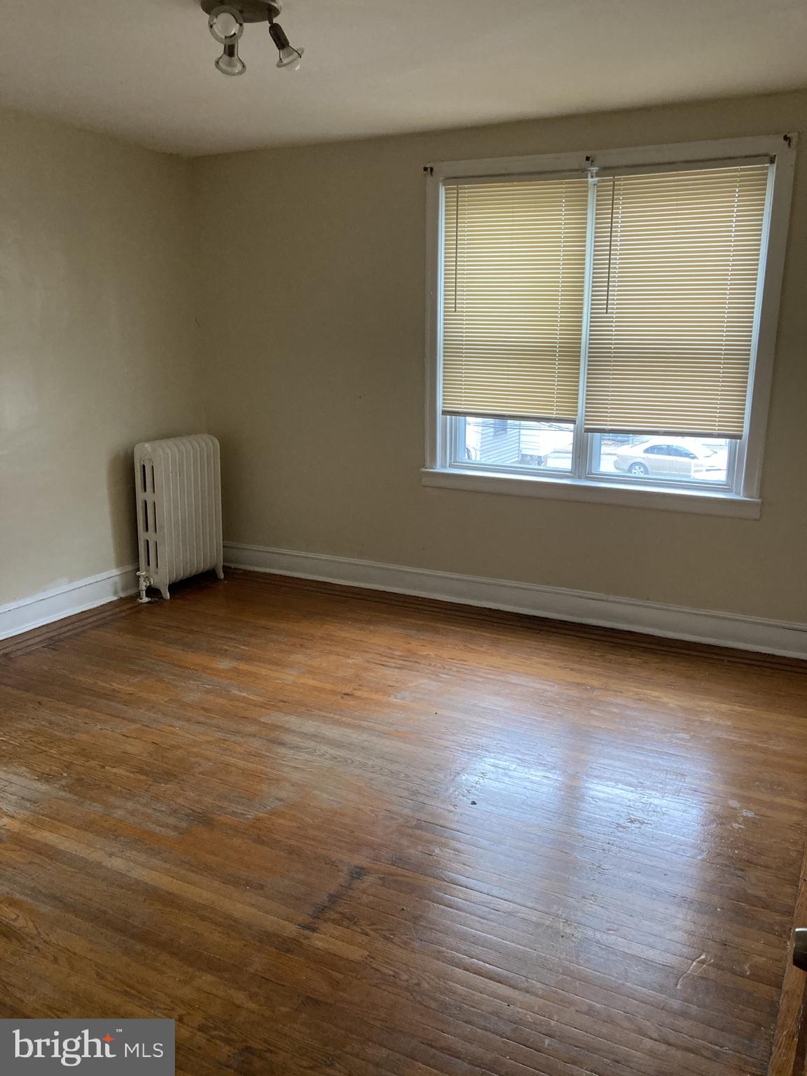 3145 North Patton Street Philadelphia, PA 19132 - Photo 12 of 16 an empty room with wooden floor and windows