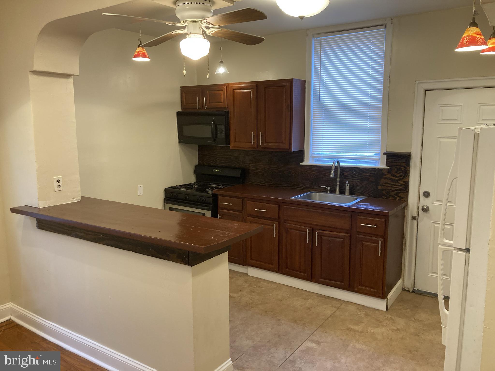 3145 North Patton Street Philadelphia, PA 19132 - Photo 6 of 16 a kitchen with a sink and a refrigerator