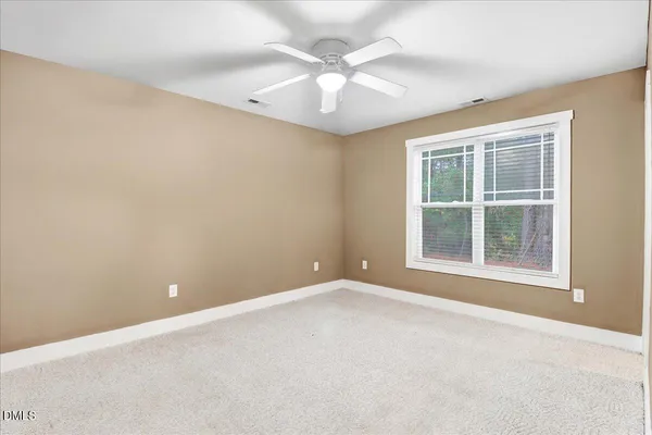 an empty room with windows and ceiling fan
