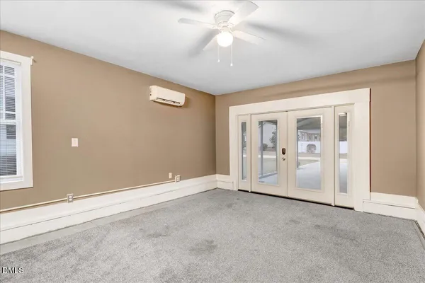 an empty room with fan and entrance