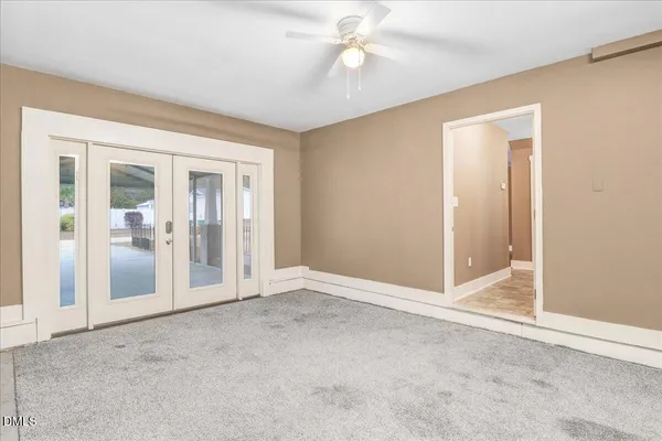 an empty room with closet and a ceiling fan