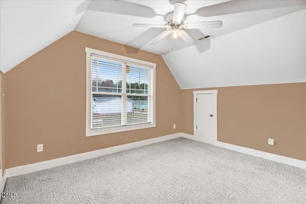 an empty room with fan and entrance