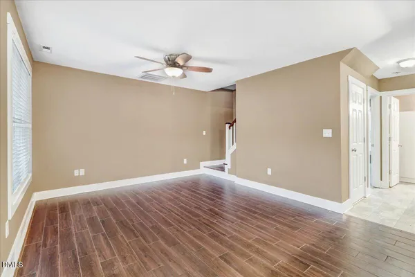 a view of an empty room with wooden floor