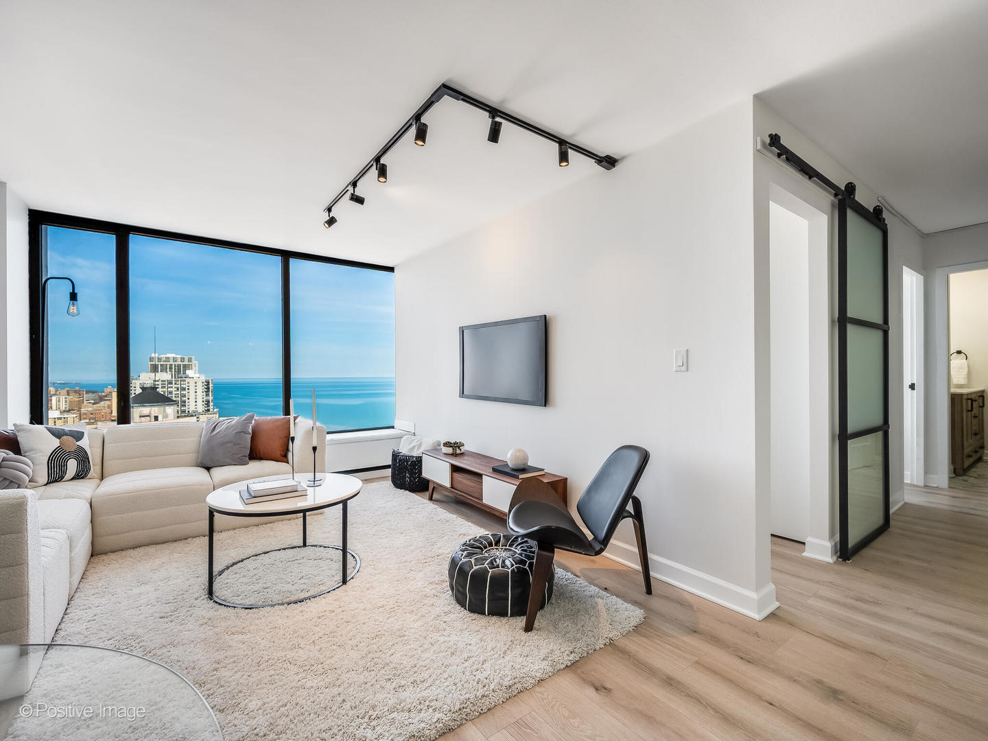 5455 North Sheridan Road, Unit 3203 Chicago, IL 60640 - Photo 3 of 21 a living room with furniture and a wooden floor