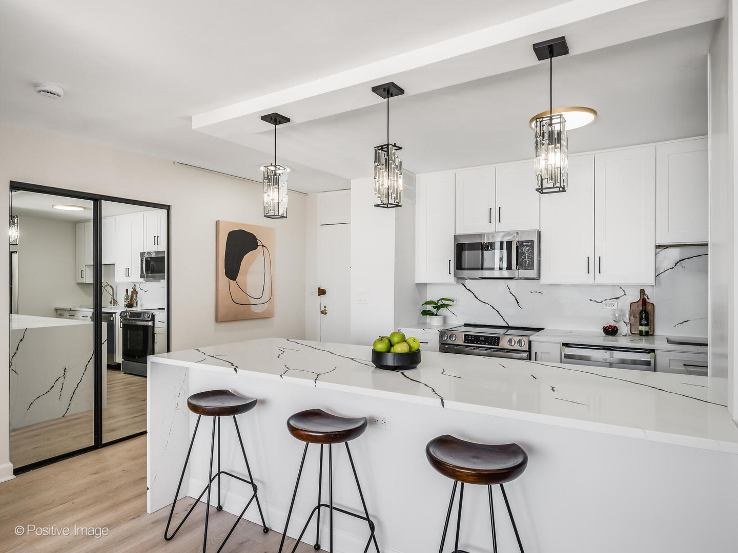 5455 North Sheridan Road, Unit 3203 Chicago, IL 60640 - Photo 7 of 21 a kitchen with a dining table chairs stove and white cabinets