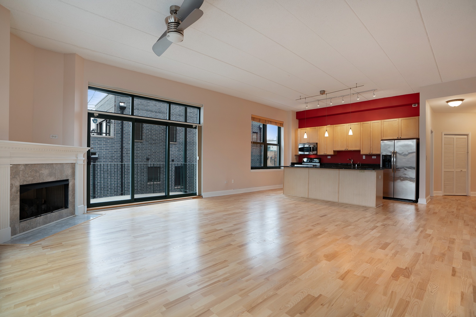 1301 West Washington Boulevard, Unit 306 Chicago, IL 60607 - Photo 4 of 11 wooden floor fireplace and windows in an empty room