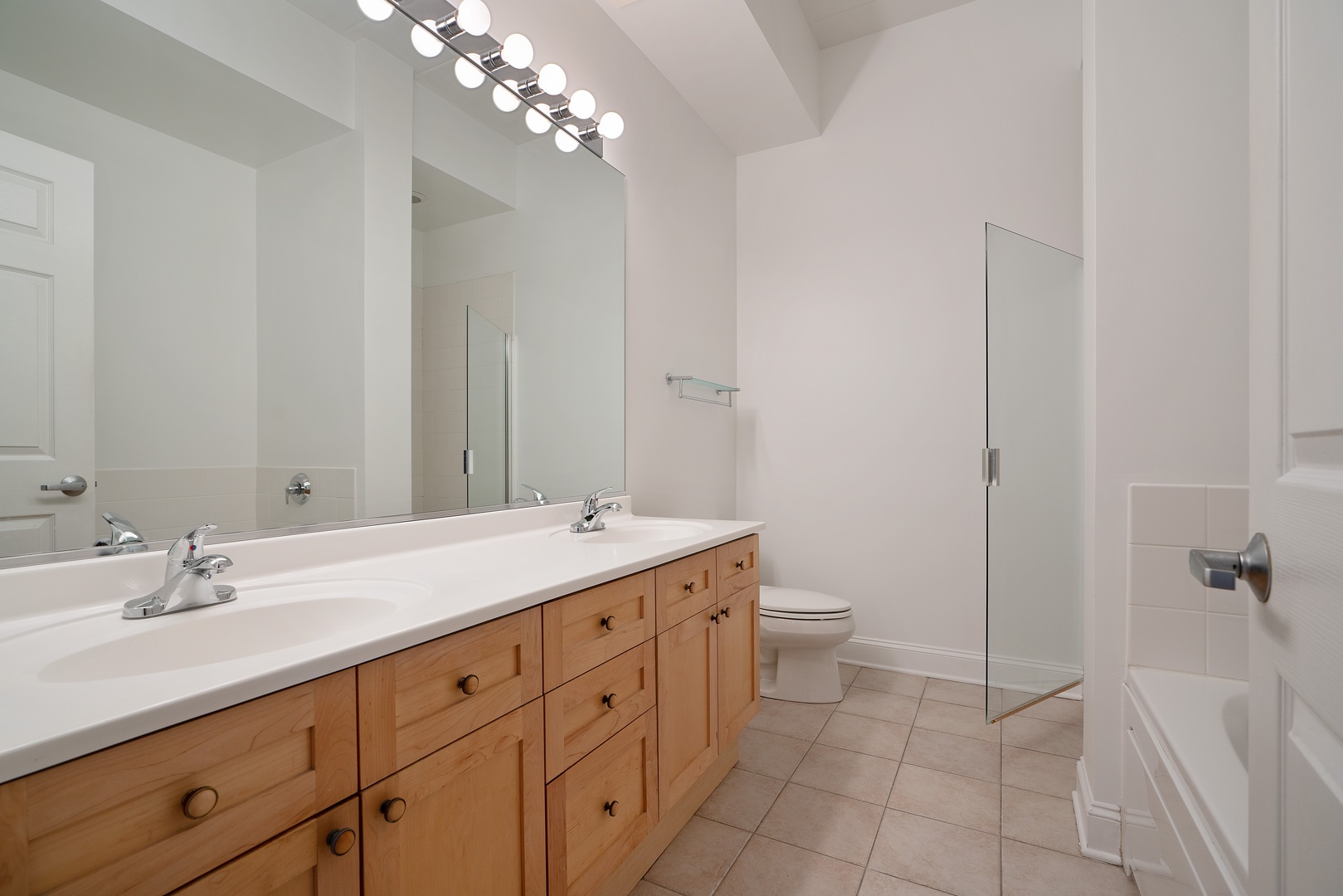 1301 West Washington Boulevard, Unit 306 Chicago, IL 60607 - Photo 7 of 11 a spacious bathroom with a double vanity sink toilet and a mirror