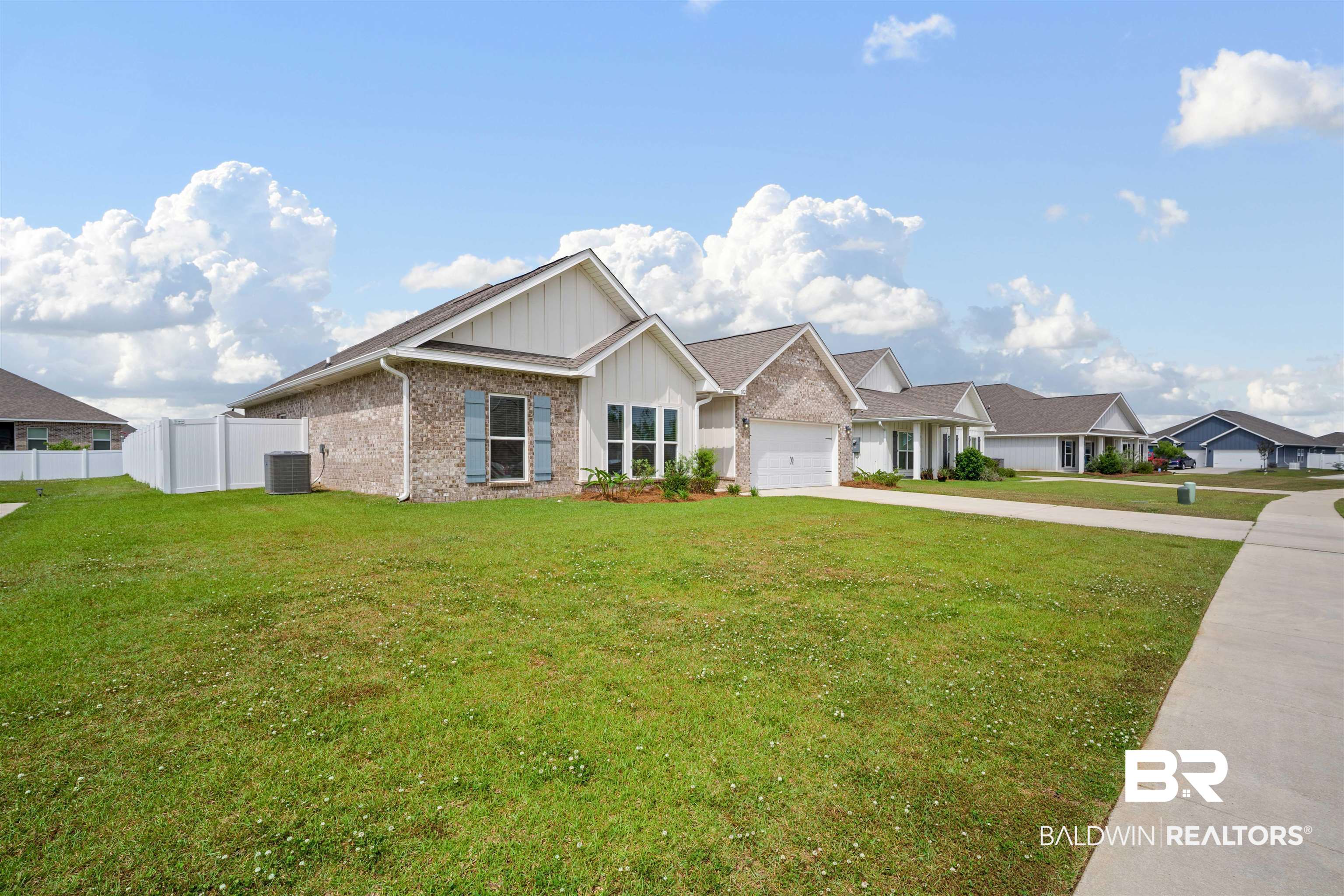 11021 Native Dancer Way Daphne, AL 36526 - Photo 2 of 35 View of front of property with concrete driveway, fence, an attached garage, board and batten siding, and a front yard