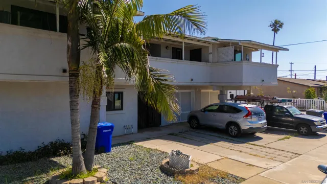 a view of a white building with swimming pool in front of it