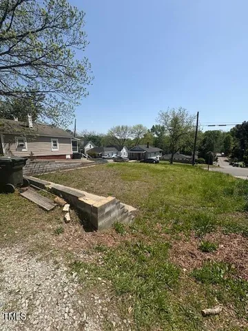 a view of a lake with a yard and a large tree
