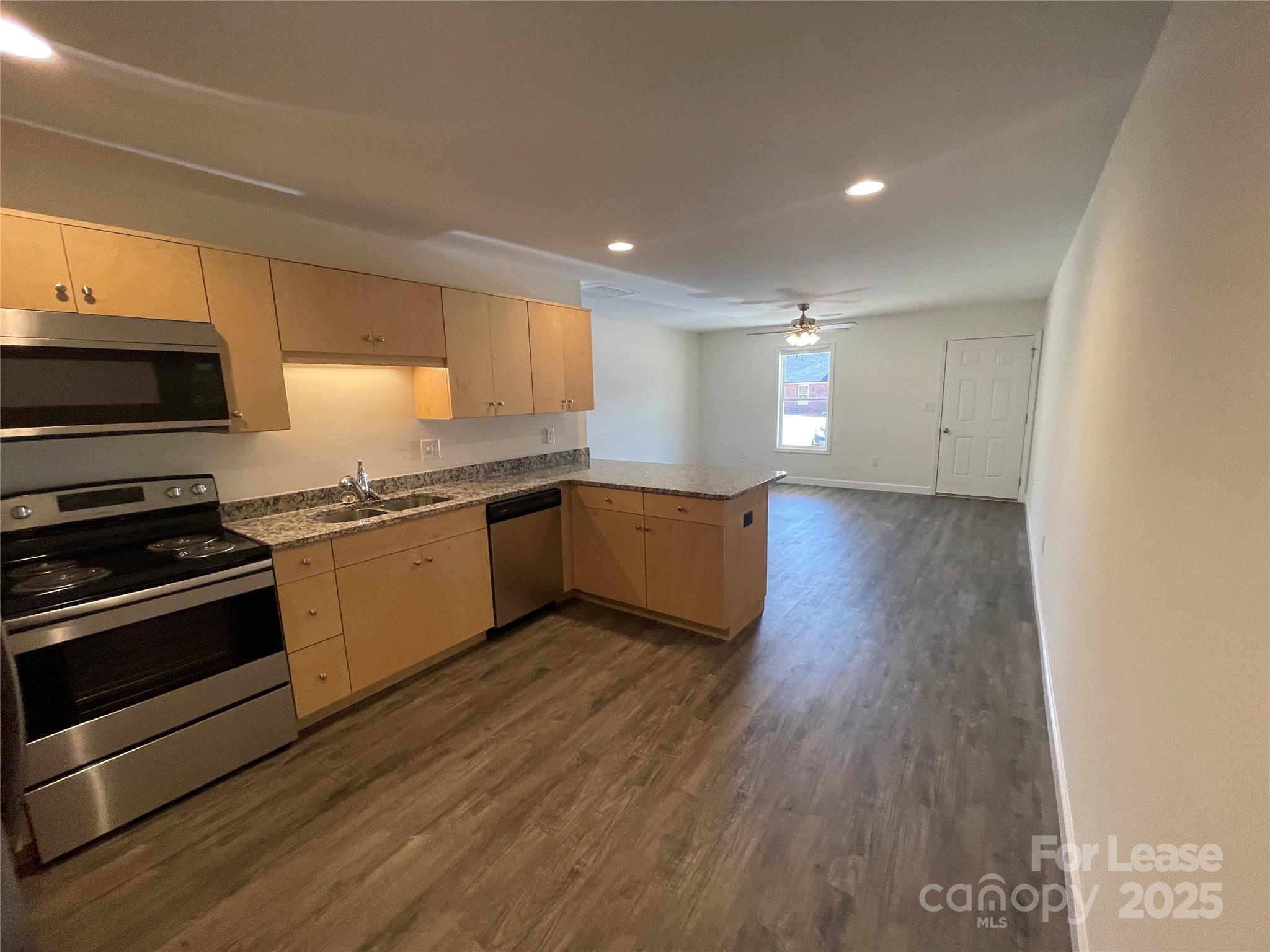 4020 Eugene Drive Lincolnton, NC 28092 - Photo 4 of 13 a kitchen with stainless steel appliances granite countertop a stove a sink and a microwave