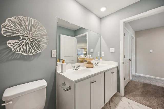 a bathroom with a toilet a sink a mirror and a shower