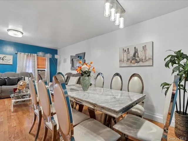 a dining room with furniture a chandelier and wooden floor