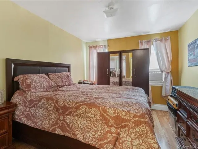 a bedroom with a large bed and a flat tv screen on dresser
