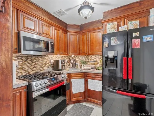 a kitchen with stainless steel appliances kitchen island granite countertop a stove and a microwave
