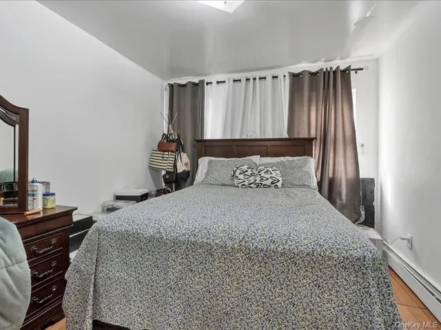 a bedroom with a bed and a flat tv screen on a dresser
