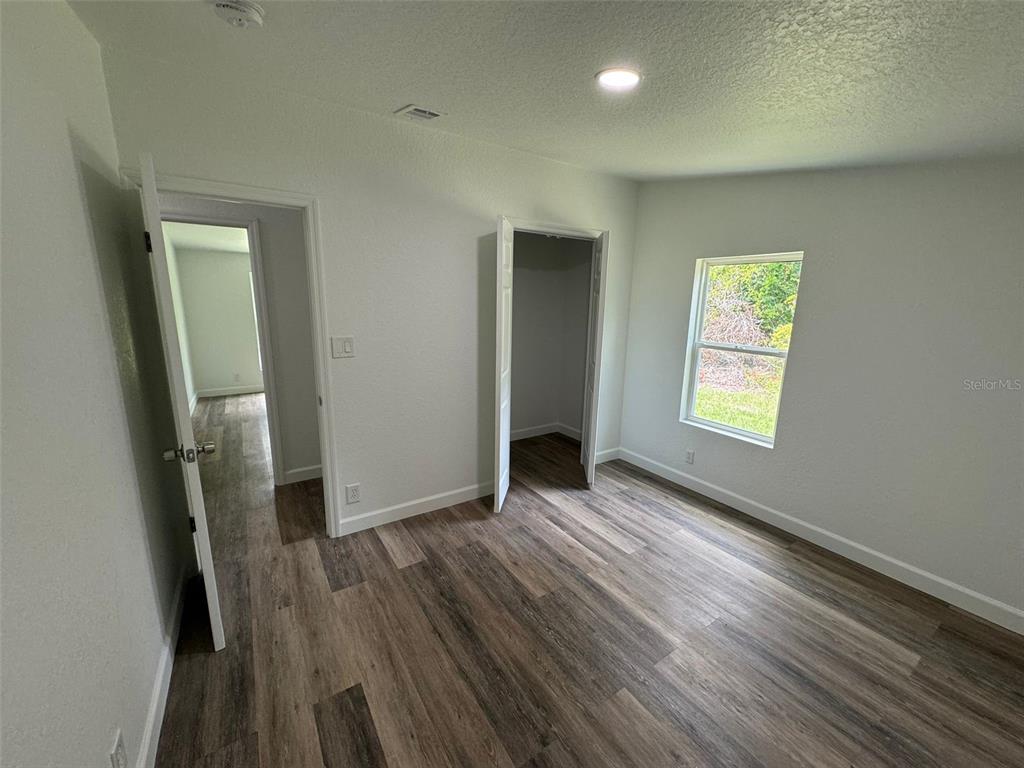 4970 Harrison Road Mims, FL 32754 - Photo 21 of 30 an empty room with wooden floor and a window